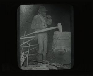 Man drinking from a bottle by a homemade moonshine still